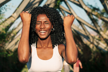 retrato de bella mujer negra sonriendo de satisfacción después de correr y hacer ejercicios en la...