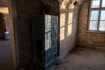 An old stove covered with ceramic tiles in an abandoned empty 18th-century house