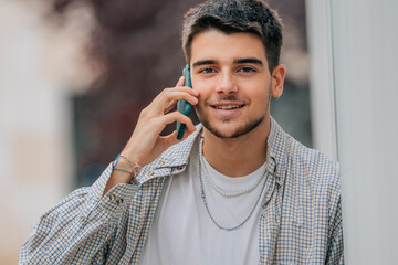 teenager boy on the street talking on mobile phone