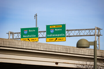 Traffic signs pointing to Nashville and Indianapolis on highway 65 as seen from under a bridge in...