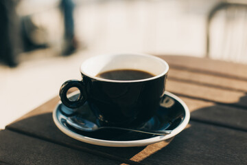 Cup of black coffee on a table in a street cafe.