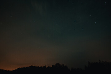 Fototapeta na wymiar Starry sky, the edge of a pine forest, morning light makes its way through the trees