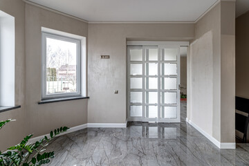 Empty house with marble floor with white French doors