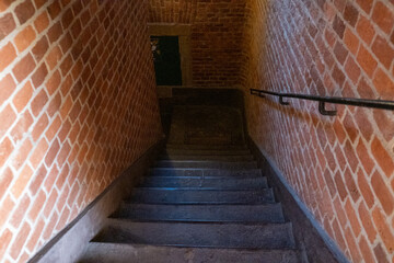 Ancient wooden staircase leading down with railings and a snub-nosed wall