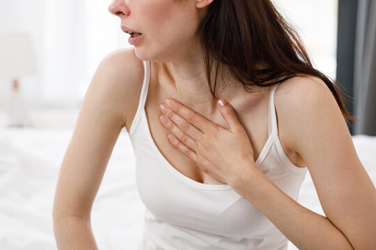 Panic Attack In Women. The Depressed Young Lady Sitting On Couch Hugging Head With Hands. Psychological Problem Concept.