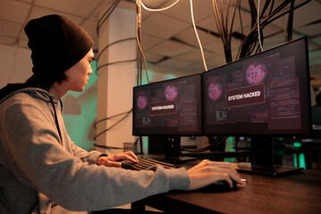 Asian programmer solving database server cyberattack, system hacked alert on computer screen, internet security technology, data breach. Cybersecurity, malicious software, ransomware attack