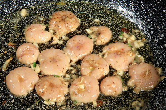 slices of fried testicles are fried on a pan with onions and spices