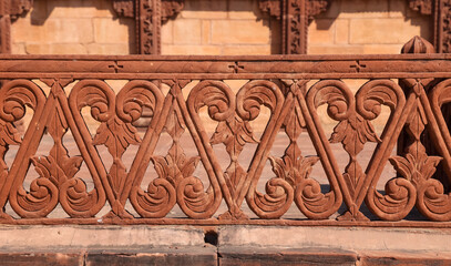 Intricate red sandstone design on the railings of historic Jodhpur fort in India.
