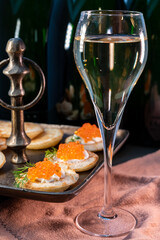 Tasting of rose brut Champagne sparkling wine with red caviar in cellars of gran cru wine house in Epernay, wine tour in Champagne, France