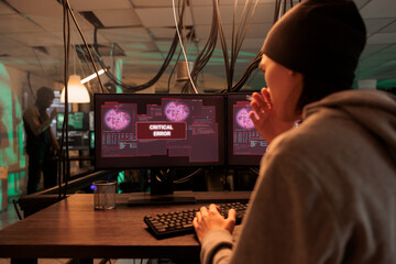 Asian criminal accessing computer system database, stealing gvernment passwords and hacking server with encryption. Cybersecurity and malicious software to plant malware at night.