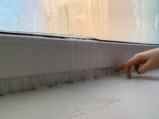 Frosty winter, Ice or frozen condensation on window sill. Fogged window, fragment. Heat leakage,...