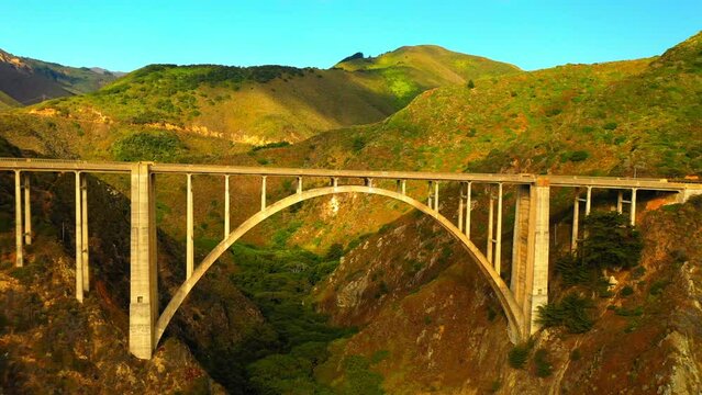 Aerial Backward Shot Of Bixby Creek Bridge By Mountains Against Clear Sky - San Francisco, California