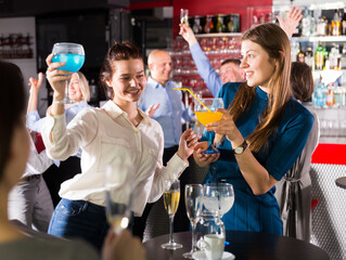Portrait of two girls having fun and talking on corporate party