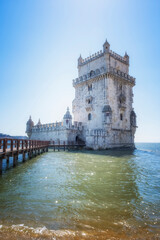 Obraz premium Belem defensive tower in the estuary of the Tagus river in Lisbon, footbridge over the water that leads to the interior, vertical