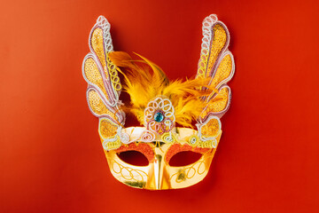 Happy Purim carnival. Carnival mask for Mardi Gras celebration isolated on red background with copy...
