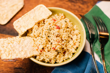 Rice bread and couscous tomato and spice salad. Tabbouleh salad. Wooden background. Food simple concept.