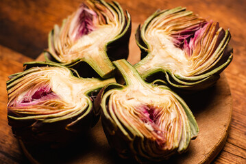 Artichokes purple halves on a wooden background. Close-up. Preparation for cooking. Vegan healthy food. Food background.
