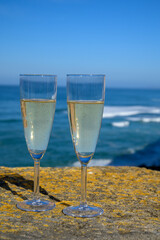 Glasses of champagne sparkling wine and view on blue Atlantic ocean, Lisbon area, Portugal