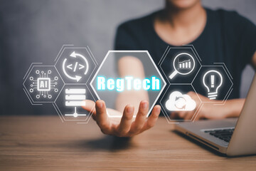 RegTech, Regulation Compliance financial control modern internet technology concept, Person hand holding RegTech icon on virtual screen.