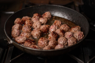 meatballs in a frying pan. Dark background.