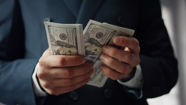 Businessman hands counting dollars close up. Unknown man calculating paper bills