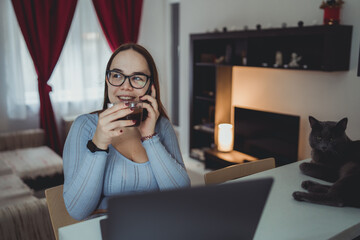 A young girl is studying or doing business from home on her laptop