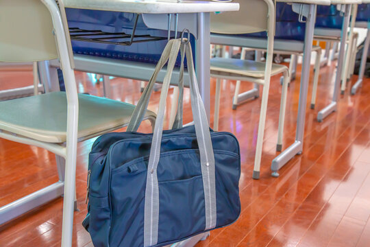 教室の机に吊り下げられたスクールバック。学校生活のイメージ、背景素材