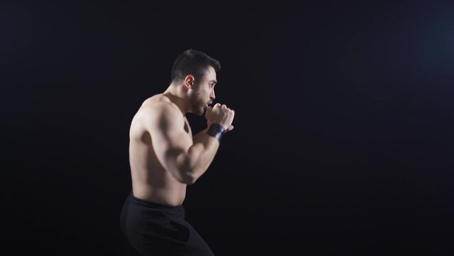 A dynamic and fast shadow boxer who adds kicks after punches. To practice.
Young athlete doing shadow boxing by himself and throwing kicks and punches.
