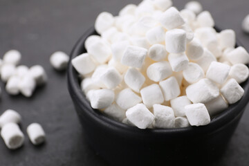 Fototapeta na wymiar Bowl with delicious marshmallows on black background, closeup