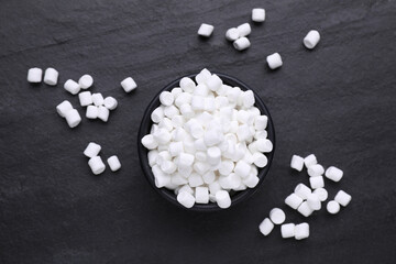 Fototapeta na wymiar Bowl with delicious marshmallows on black background, flat lay