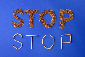 Words Stop made of dry tobacco and matches on blue background, flat lay. Quitting smoking concept