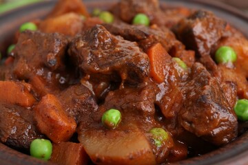Delicious beef stew with carrots, peas and potatoes, closeup