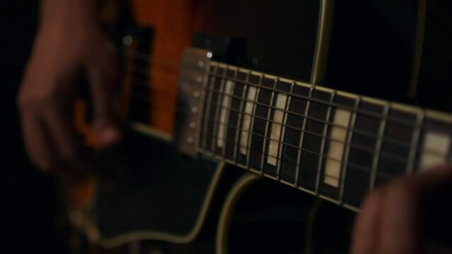 A person playing chords on a brown and black Gibson guitar 