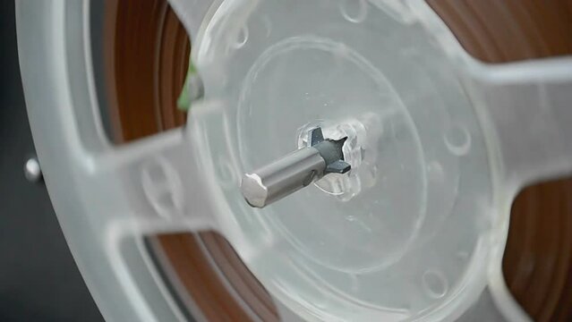 retro tape recorder aka record player closeup, vintage audio tape bobbin in rotation, nostalgia technology diversity