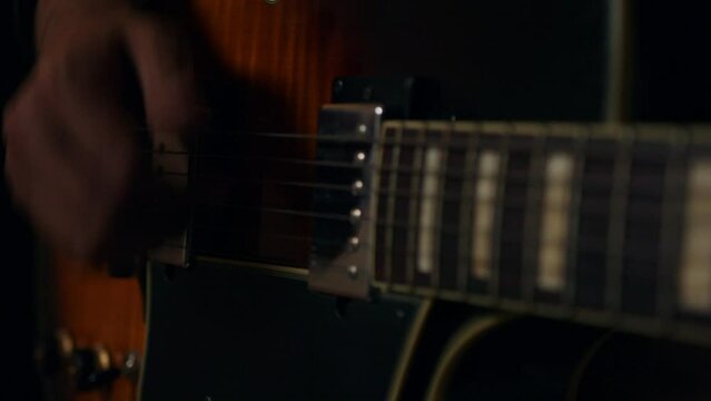 Close up of the hangs playing a Gibson guitar