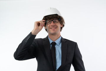 Portrait of Smiling young business man in black suit protective construction helmet, fixing his glasses isolated on white background.
