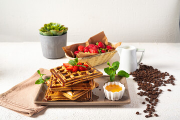 Viennese waffles with strawberries and mint on a white background