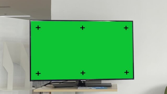 Television on desk with green screen for product display, Television mockup screen, Zoom in shot.