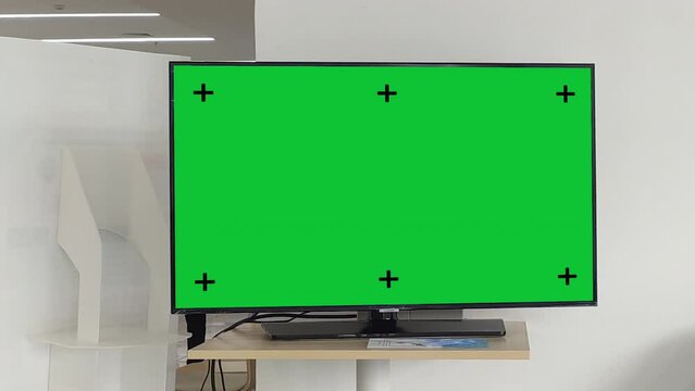 Television on desk with green screen for product display, Television mockup screen, Planning shot.