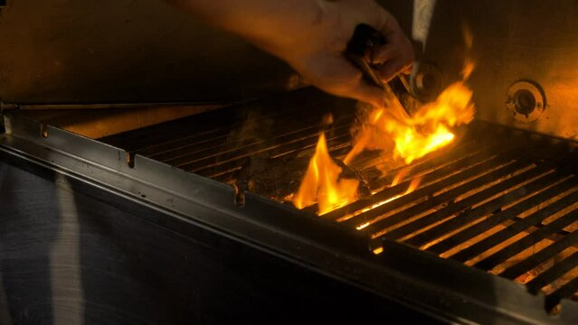 Cheff grills meat, with flames