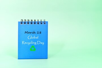 March 18 as Global Recycling Day date reminder on blue desk calendar. Celebration concept.