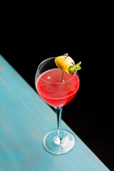 Refreshing tropical boozy cocktail with lemon juice on black background