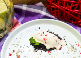 Chocolate cake with ice cream and mint leaves on a white plate