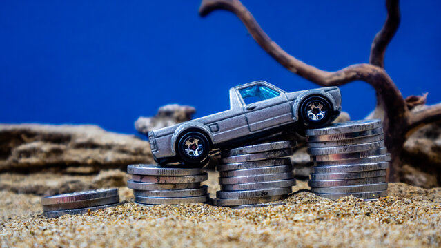 minahasa, Indonesia : January 2023, toy car on a pile of coins, saving for the future, managing successful transportation business technology concept