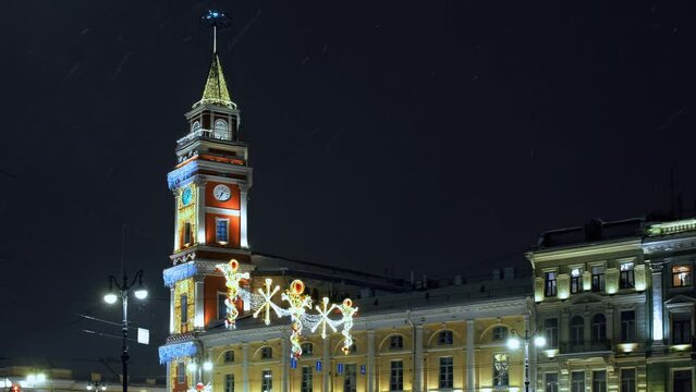 City Duma tower decorated to the New year under heavy snow at the evening. St.Petersburg, Russia