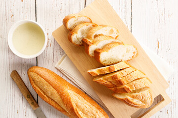 Baguette slices on wooden plank.