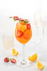 Classic cocktail in glass on white background with orange, alcohol, strawberry  soda and ice