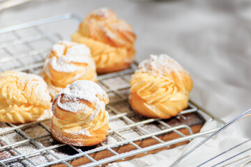 Choux cream, delicious pastries sprinkled with icing.