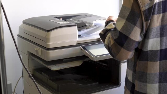 Documents printing concept : Business man hand pressing button machine supplies in control panel laser printer for copy scanner and printing document report graph chart in busy office