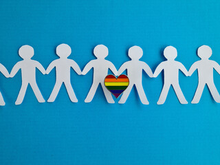Group of figurines hold hands and lgbt sign